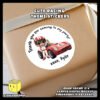 Personalize-Cute-Racing-Theme-Sticker-D-pasted-on-a-Gift-Box Digital mockup of a cute racer posing beside his red sports car round sticker pasted on gift box