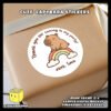 Digital-Mockup-of-Cute-Capybara-sitting-on-a-small-rainbow-Theme-Sticker-Design-A-Pasted-on-Gift-Box Digital mockup of a cute capybara round sticker design A pasted on gift box